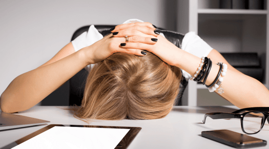 A frustrated woman head-desking over her small business website. 